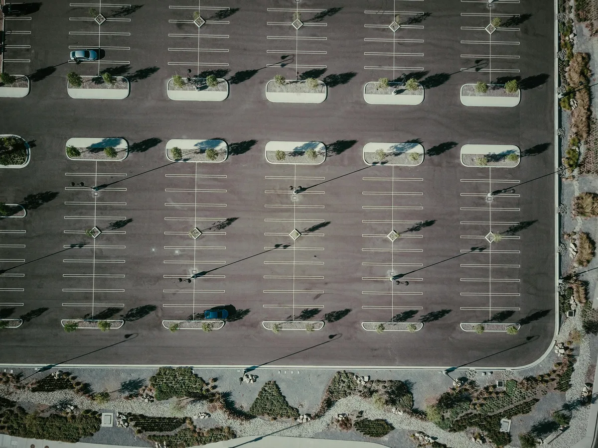 Aerial view of a commercial parking lot showing organized stall markings, drive aisles, and ADA accessible spaces
