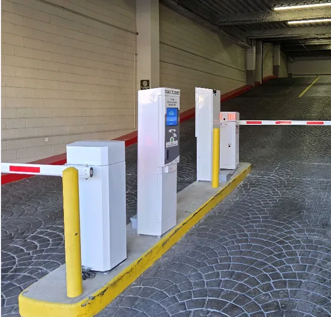 Parking BOXX entry lane system installed at a gated parking facility — ticket machine, barrier gate, and LPR camera